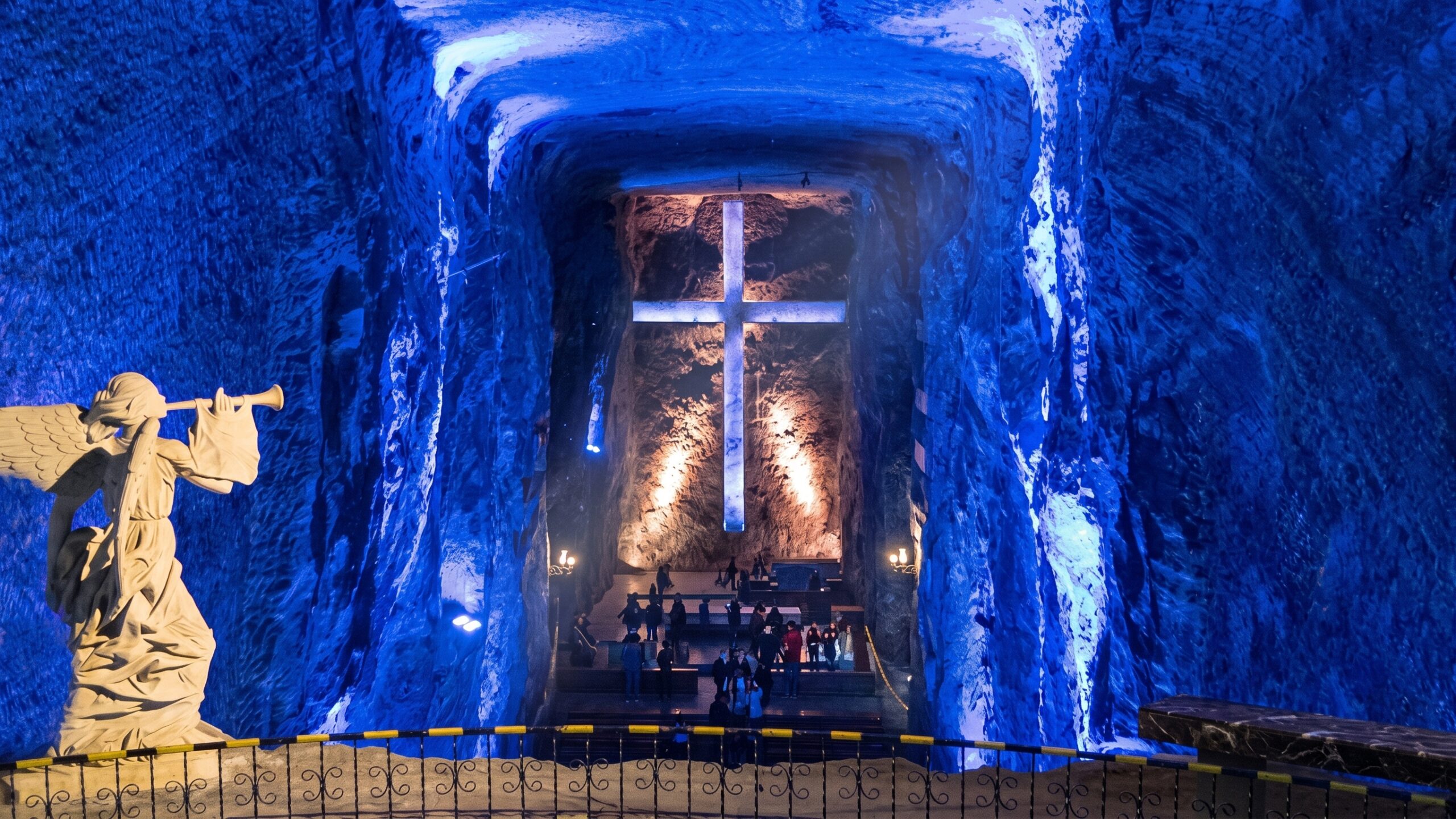 Interior de la Catedral de Sal de Zipaquirá iluminado en azul, con una cruz al fondo